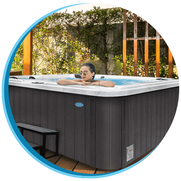 A woman sitting in the middle of an outdoor hot tub.