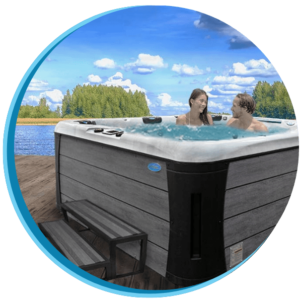 Two people in a hot tub with the water behind them.