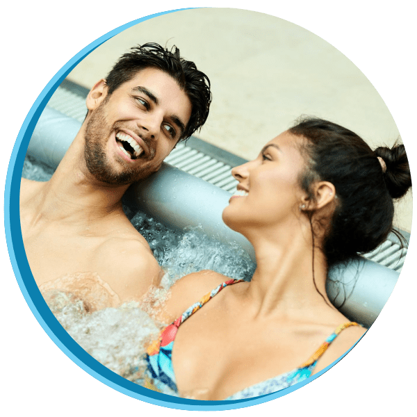 A man and woman in the tub smiling for the camera.