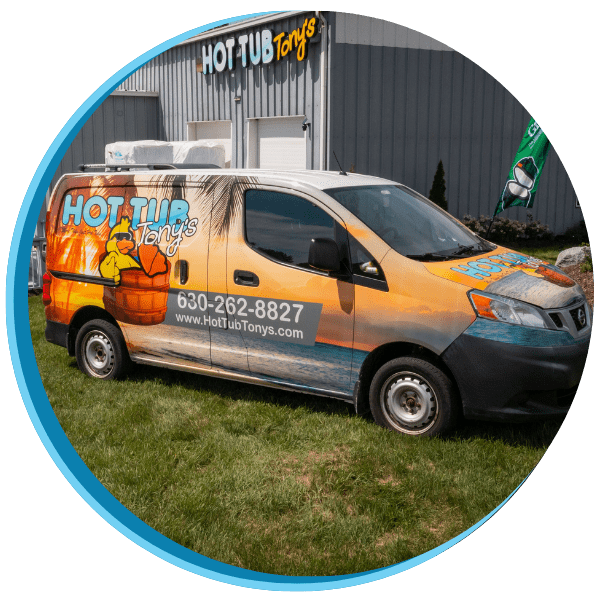 A van with an orange and black wrap parked in front of a building.